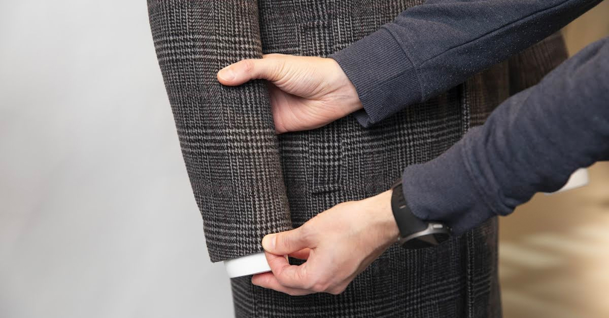 Stylist straightening arms of jacket.