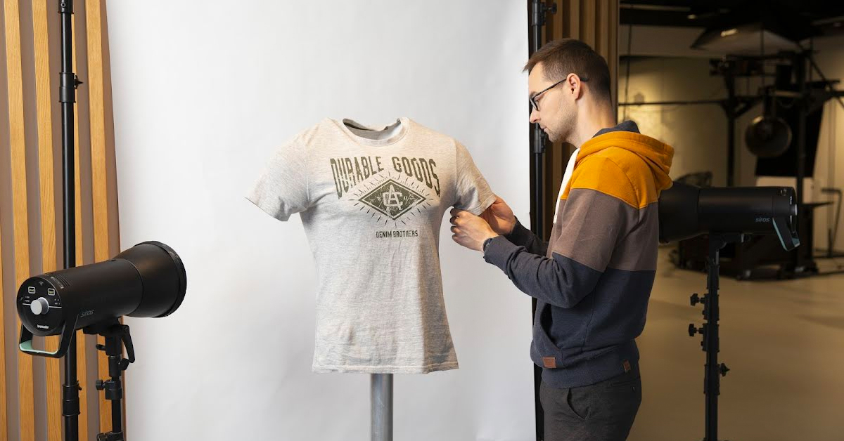 Photographer styling a t-shirt for photoshoot.