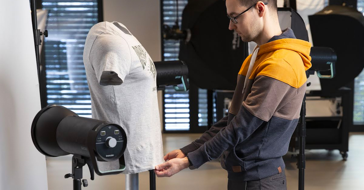 Photographer, t-shirt, mannequin and light setup.