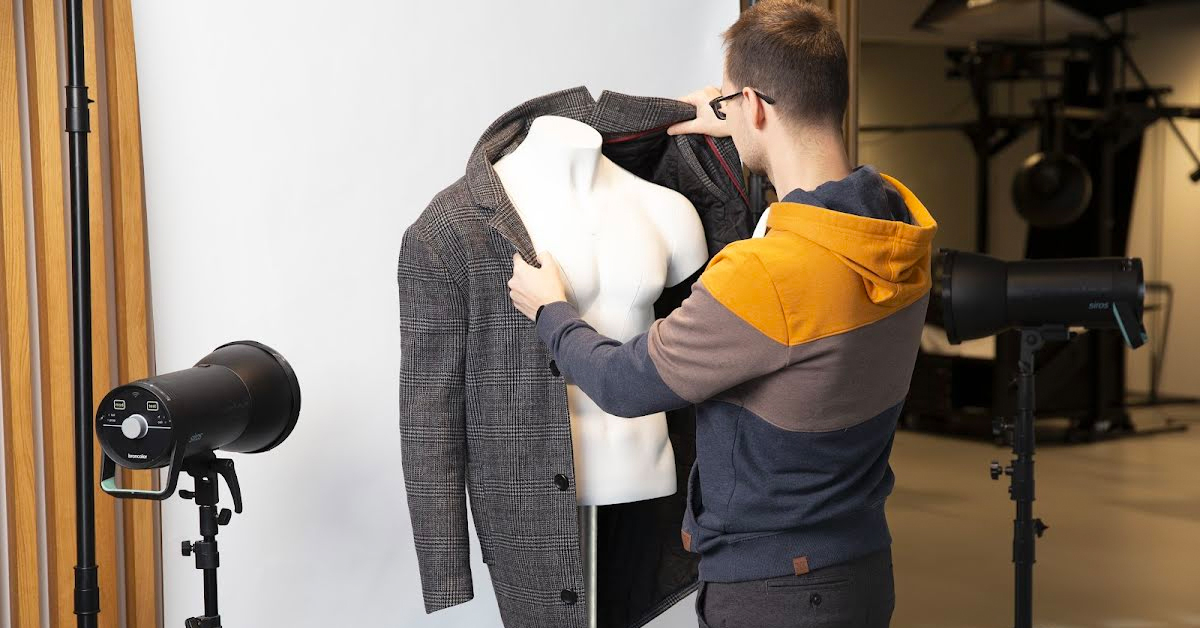 Stylist preparing mannequin for photography.