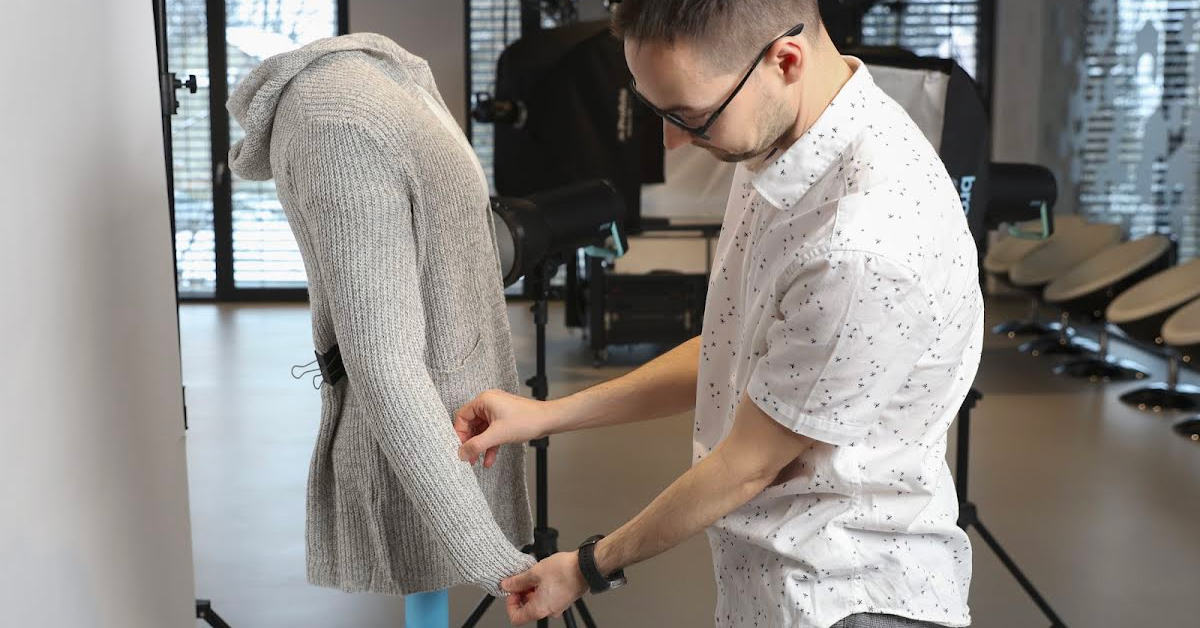 Photographer styling clothing on mannequin.