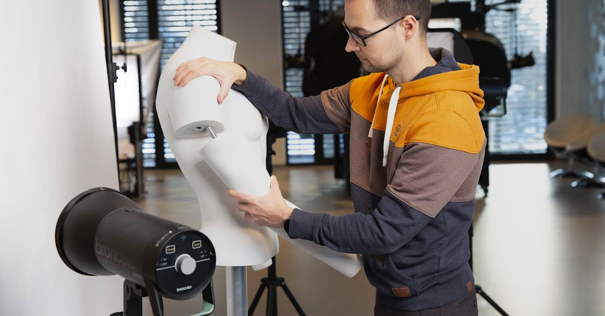 Preparing a special multi-part mannequin to photograph a t-shirt begins first by removing the arm and chest pieces.