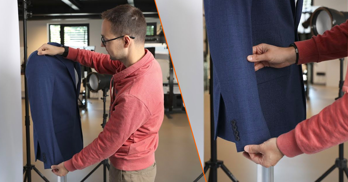 A product photographer carefully prepares a men’s blazer for on-mannequin photography