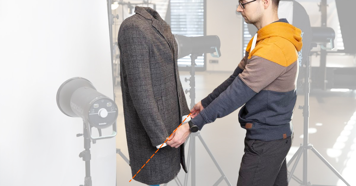 Photographer positioning arms and hem of coat.