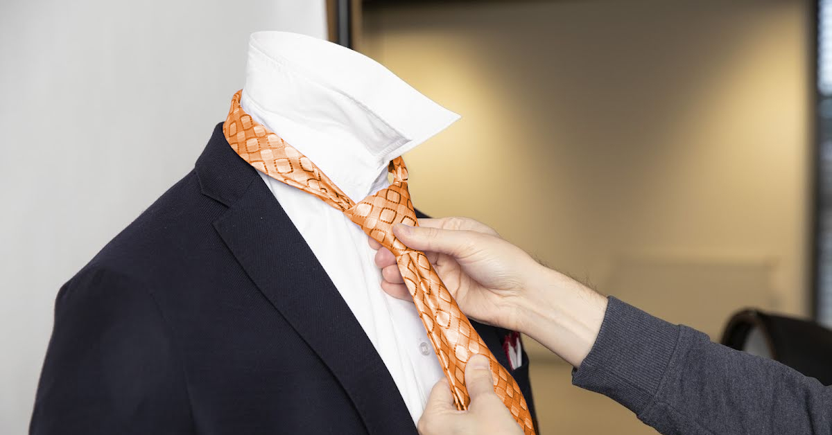 Close-up of putting tie on mannequin neck.