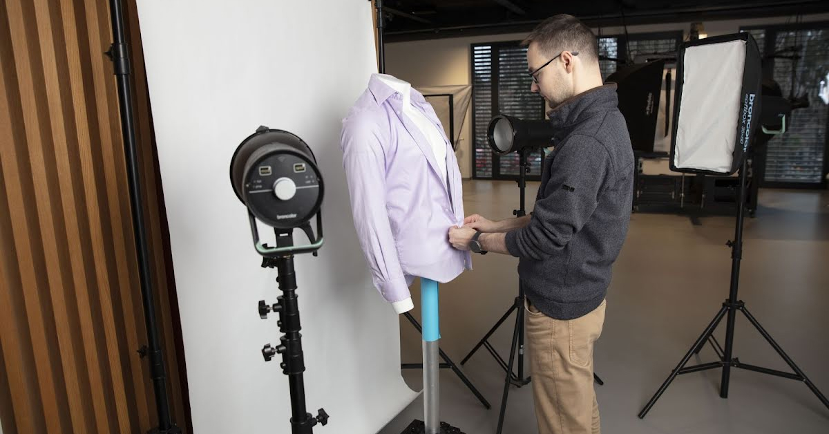 Distance view of photographer, studio, mannequin and shirt.