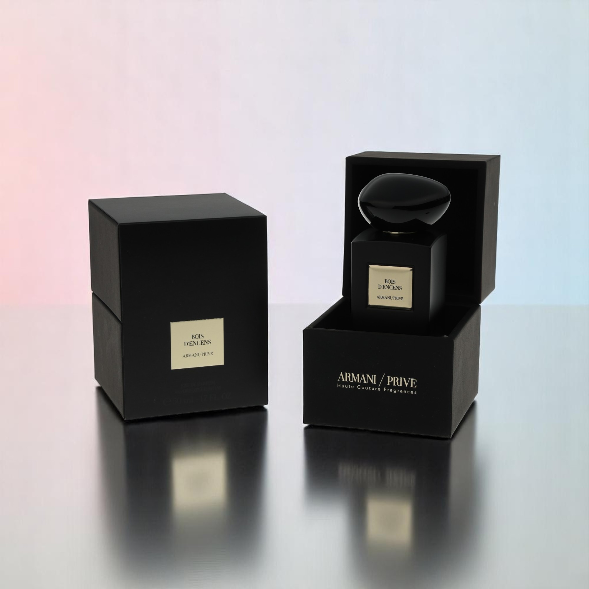 A packshot of the perfume bottle with its packaging sits on a table reflecting parts of the items.